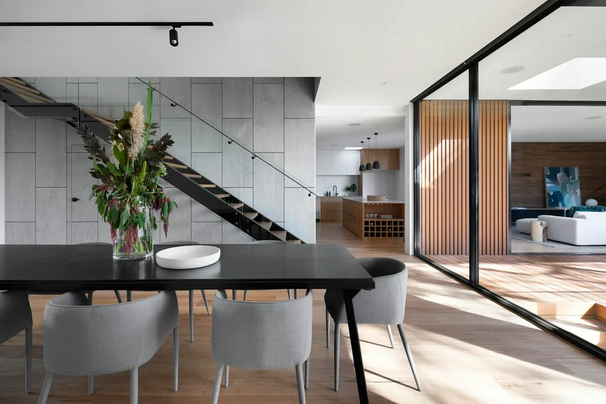 An open dining area with grey seating and garden views